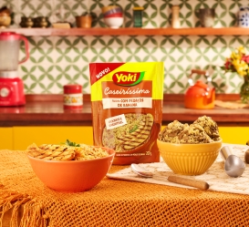 Two bowls of banana farofa sit on a kitchen counter with a Yoki Caseiríssima package displayed between them.