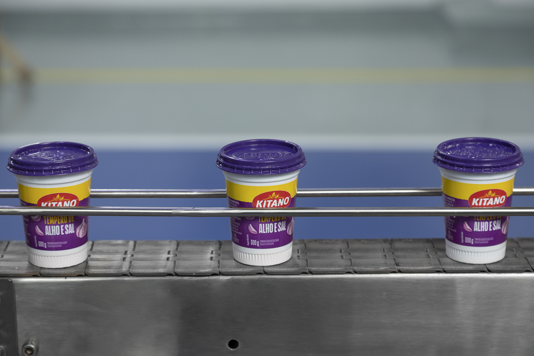 General Mills Brazil- Image of three containers of Kitano La Alho E Sal products on a conveyor belt, prepared for packaging.